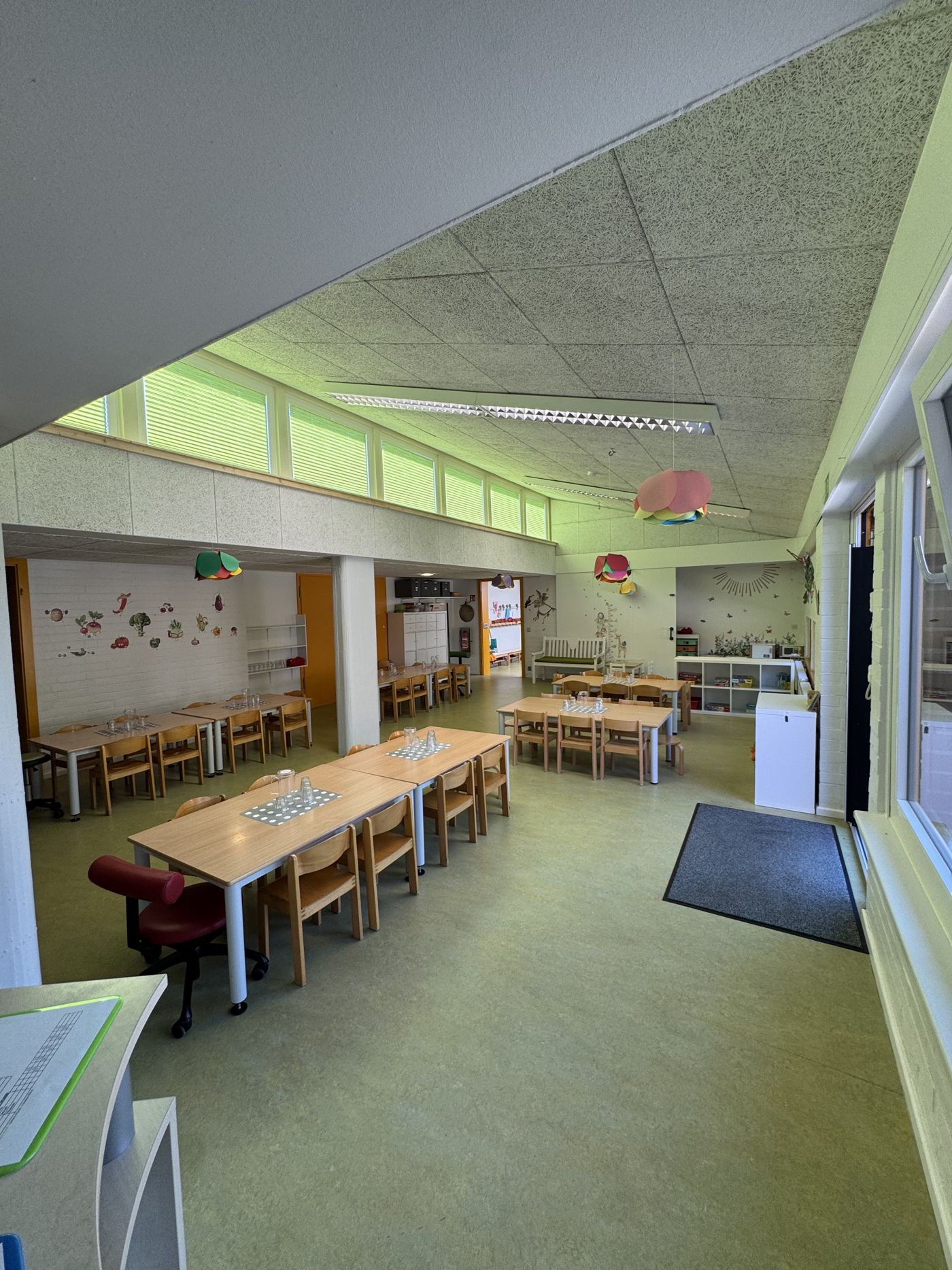 Heller Flur mit bunten Kinderbildern beim Eingang der Kindertagesstätte